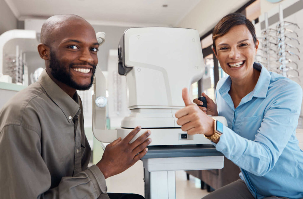 A female Optometrist giving a thumbs up and a smiling man satisfied with the test.