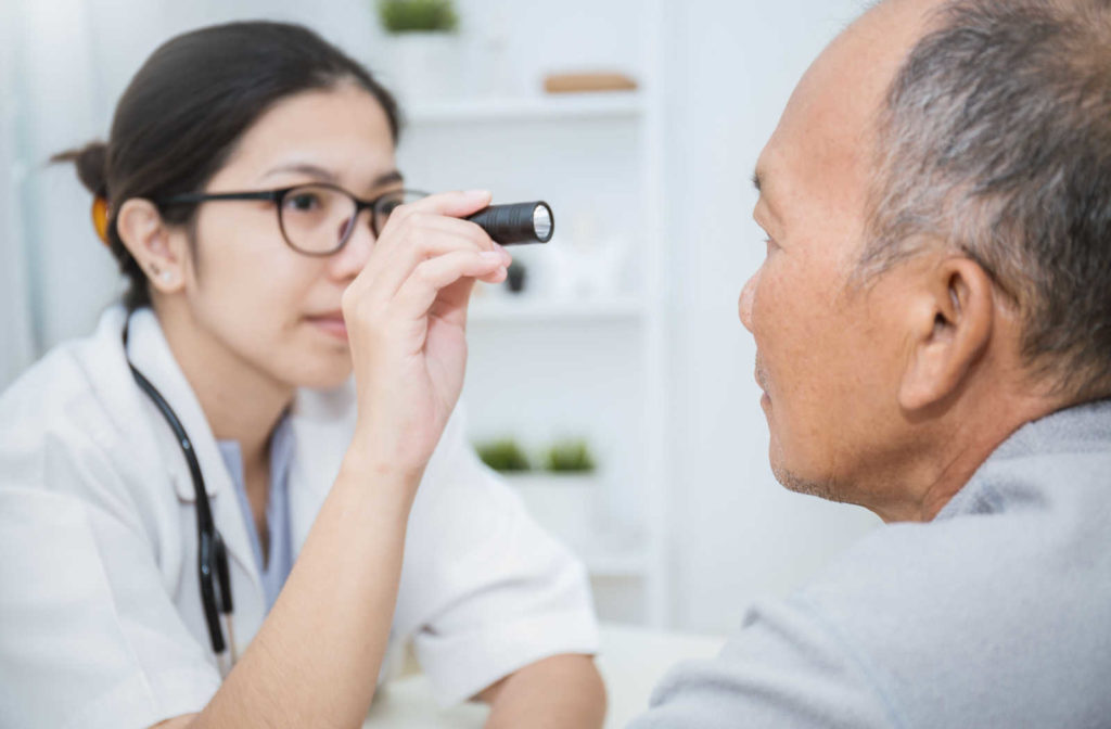 A senior man and his female optometrist performing an eye exam.
