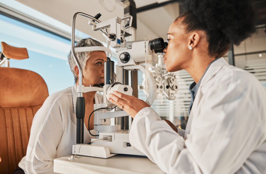 An optometrist performs a slit-lamp exam on her patient.