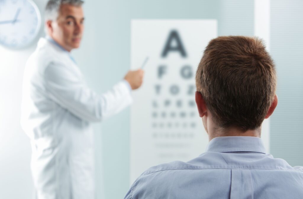 View from behind a patient's head as he sits in a chair and looks at a Snellen chart as directed by the optometrist